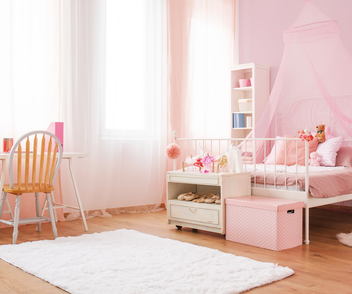 Rosanes Kinderzimmer mit einem Kinderbett und Spielzeug. 